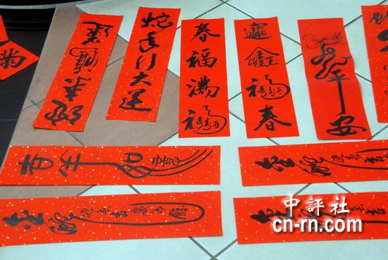 中評社台南2月5日電(記者 趙家麟)農曆新年腳步已近,台南市議會5日邀請多位書法家在大廳揮毫春聯,除了迎春納福、招財進寶的拚經濟春聯外,書法家運筆走墨,延伸的線條與筆觸的創意,也展現了蛇年的靈活與氣勢。 台南市書法學會理事長楊玉秀表示,今有十五、六位會員書法家參與了議會的寫春聯迎新春活動,以書法迎春和民眾結緣,有濃濃的年味。 楊玉秀指出,今年是蛇年,取中國文字變化字型,在筆觸線條做變化,各家都有創意。雖不畫蛇,但以書法行草拉長或延伸字型、線條,靈活躍然於紙上,也很有蛇年的味道。另外,年字體寫
