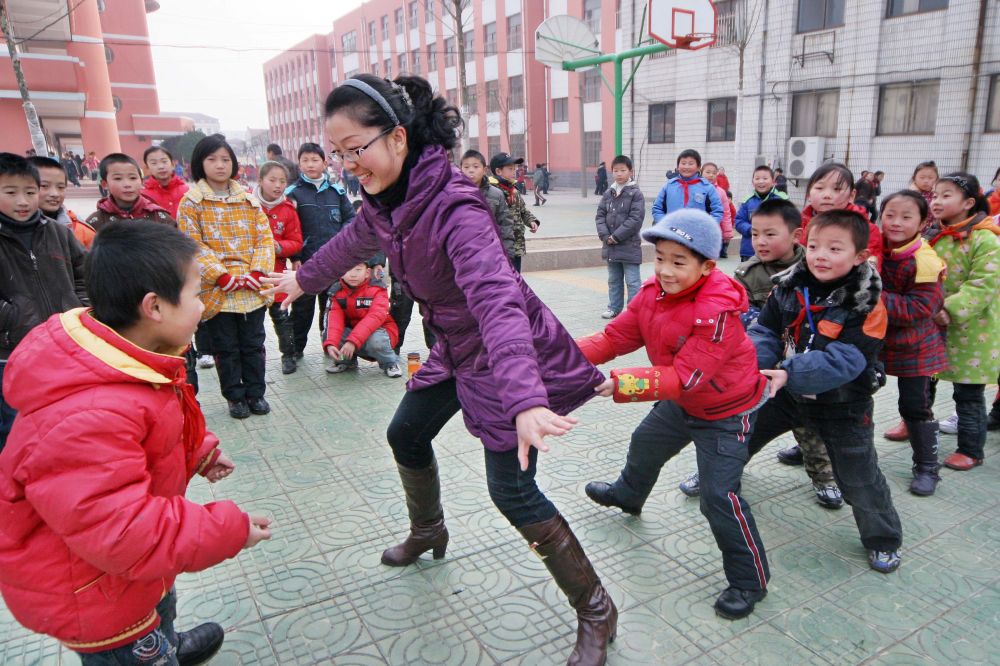 江苏省赣榆县实验小学老师和学生们一起玩"老鹰捉小鸡"游戏(2009年11