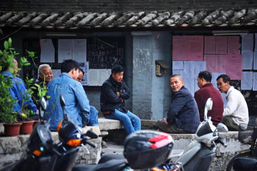几个村民坐在一起聊天.