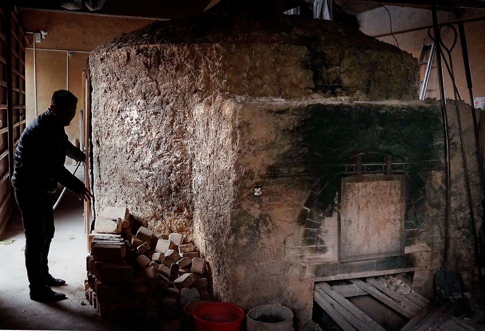 11月1日,一位工人在神垕古镇的一处钧瓷生产厂家内检查传统窑炉的烧窑