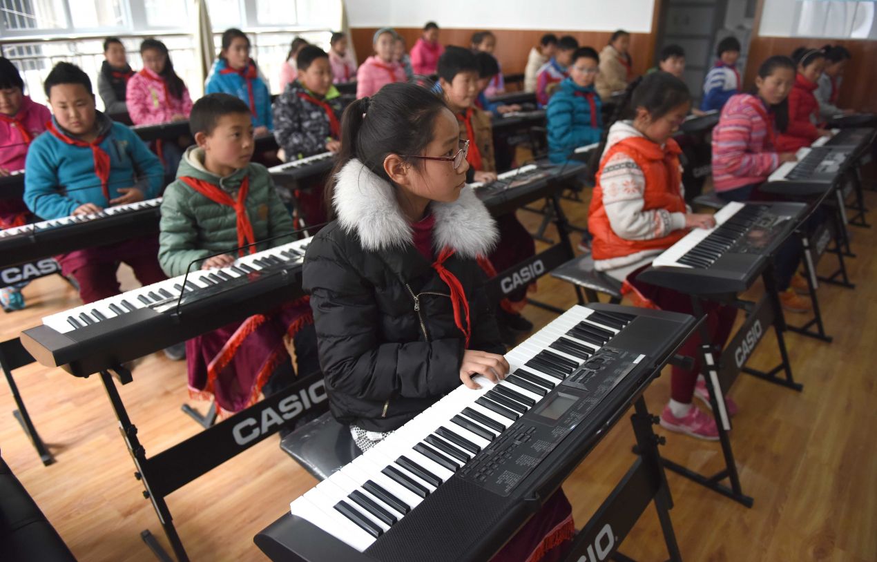 四川省甘孜藏族自治州康定县东大街小学的学生在学习电子琴(2015年3月